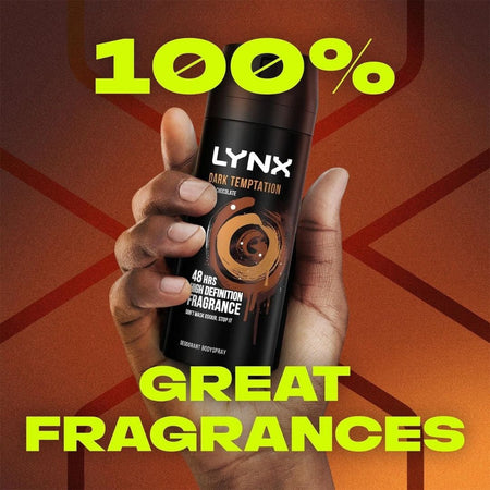 Lynx Dark Temptation Deodorant Body Spray 150ml being held in a hand on a bronze background with the caption '100% Great Fragrances'