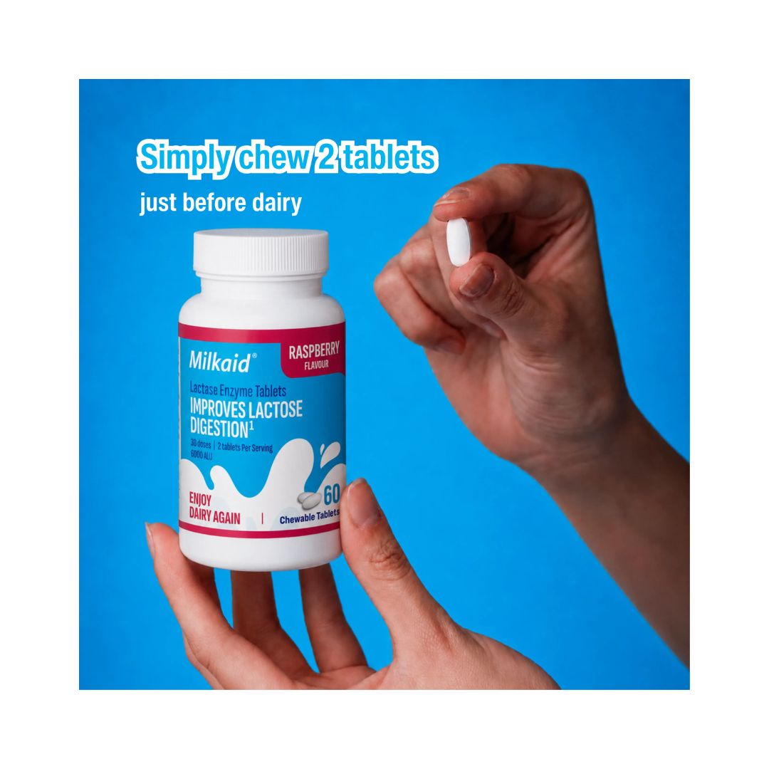 Milkaid Lactase Enzyme Tablets being held by someone on a blue background and dosage information exhibited at the top