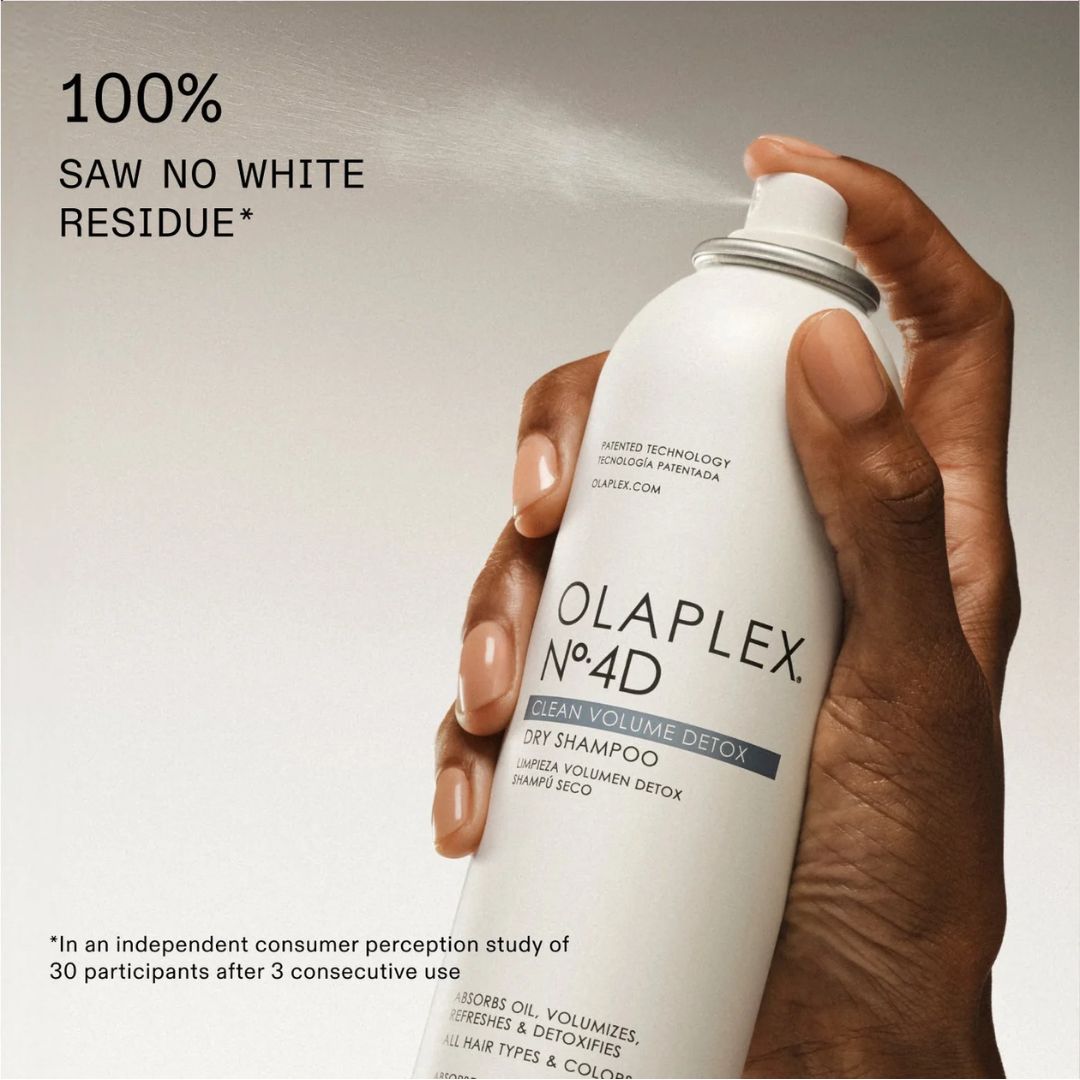 Olaplex No.4D dry shampoo bottle held by a hand with text about product effectiveness.