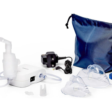 A nebulizer kit on a white background, including a white nebulizer machine with tubing, two clear face masks, a black power adapter, two small caps, and a blue drawstring storage bag.