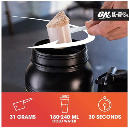 A hand using a scoop to add Optimum Nutrition powder into a large black shaker bottle, with a white arrow indicating the motion. The bottom features an orange banner with white icons and text stating '31 GRAMS', '180-240 ML COLD WATER', and '30 SECONDS'.