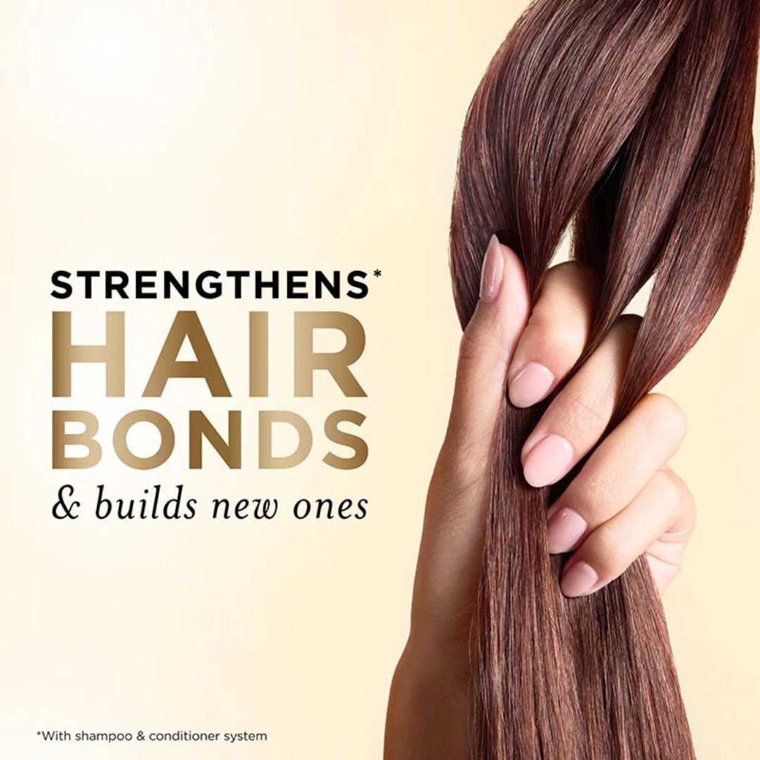 Hand holding straight brown hair with text about strengthening hair bonds on a beige background