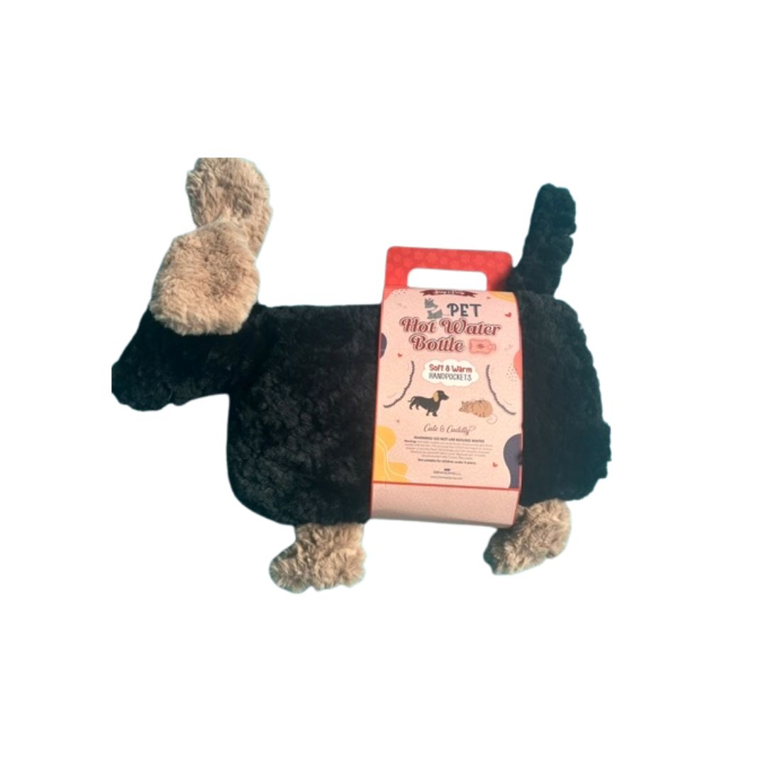 A plush dog-shaped hot water bottlein black with tan paws and ears, wrapped in a pink and red paper band that reads 'PET Hot Water Bottle'.