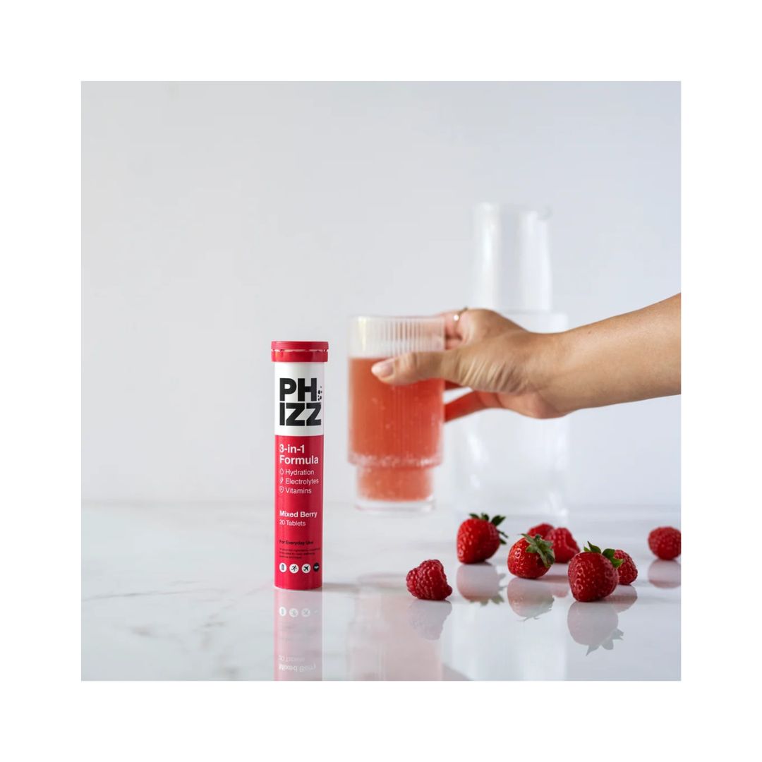 Phizz Daily 3-in-1 Hydration being dissolved in a glass of water with the container in the foreground
