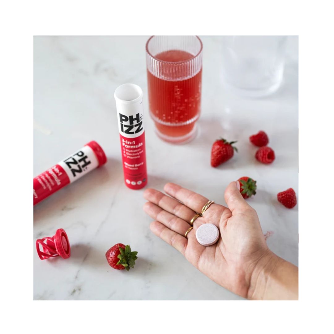 Phizz Daily 3-in-1 Hydration on a kitchen countertop and a tablet in a womans hand