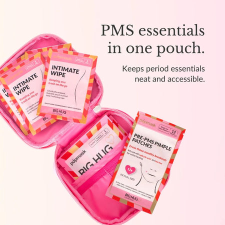 A pink zip pouch containing several BIG HUG mask packets, including Intimate Wipe and Pre-PMS Pimple Patches, with promotional text on a soft pink background.
