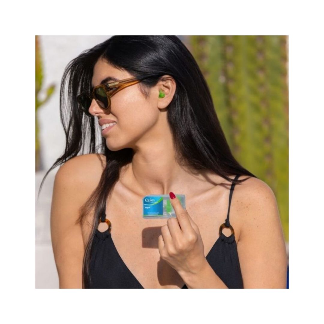 Quies Specific Aqua Ear Plugs being held by a smiling woman with sunglasses