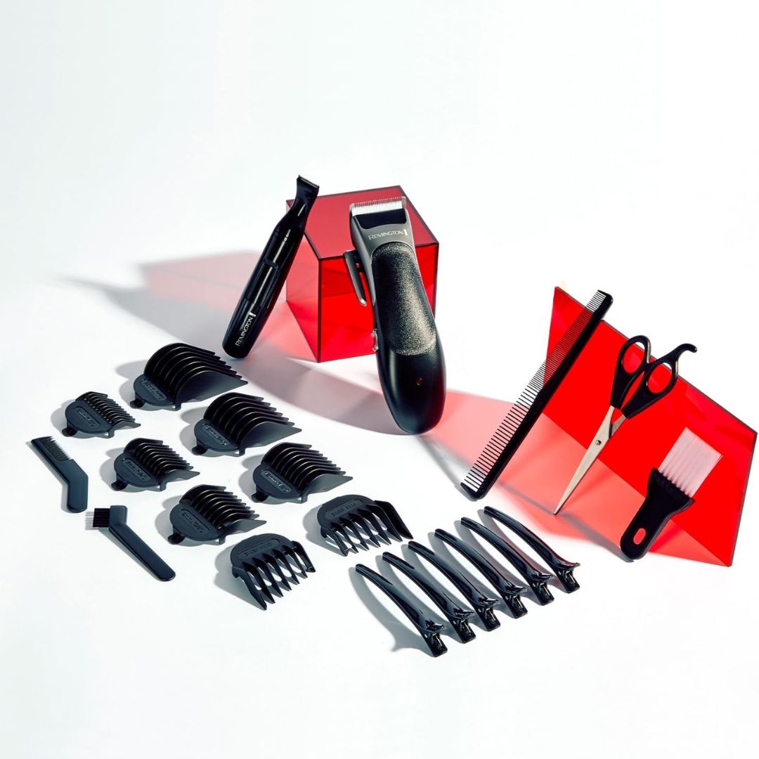 Black hair trimmer kit with multiple guide combs, scissors, a comb, and a brush, arranged on a white background with red translucent display blocks.