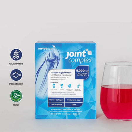 Box of reviveactive joint complex supplement with a glass of red liquid on a light gray background