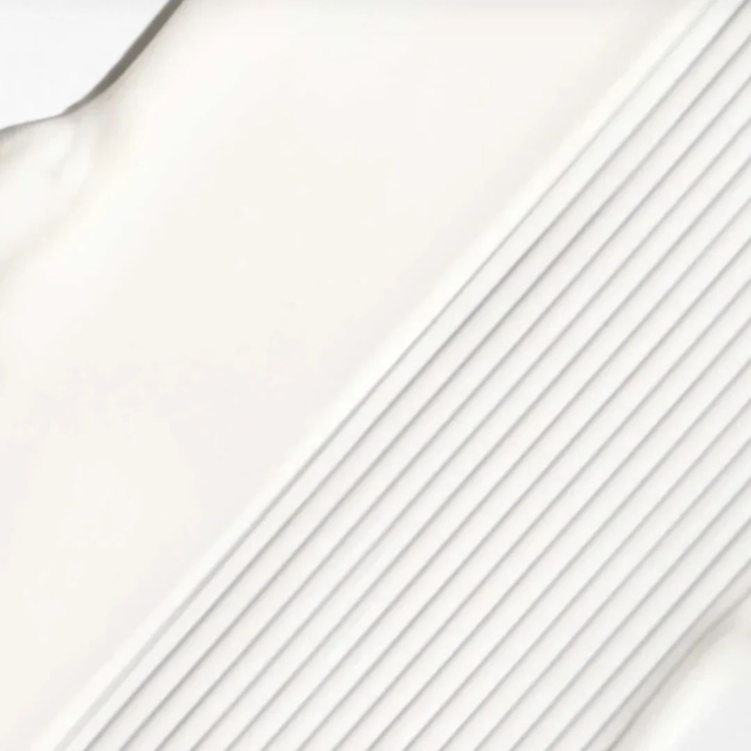 A close-up of a white textured surface with diagonal ridges and a smooth white area on the left.