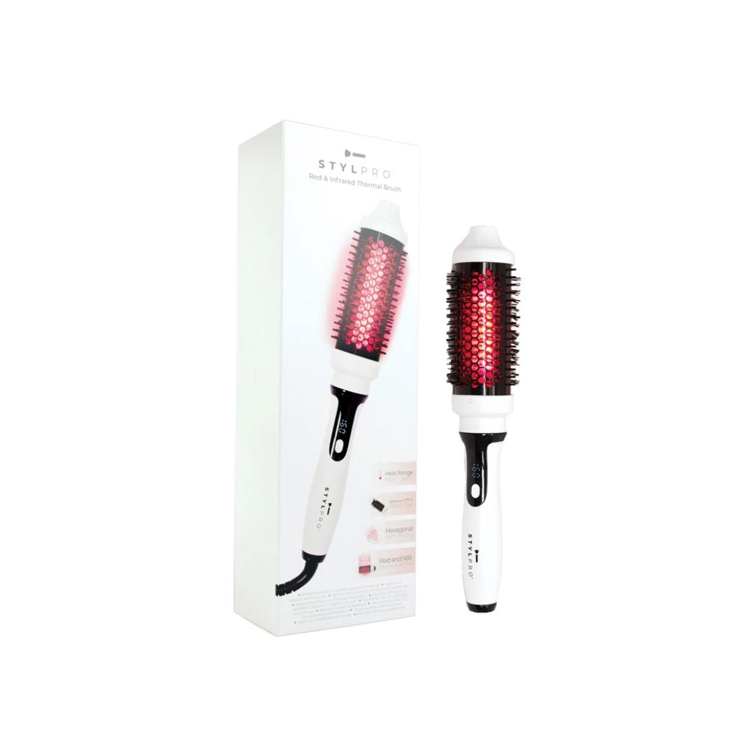 A white and black round hot air brush styling tool shown next to its white retail box on a plain white background. The brush has a glowing red light indicator on the bristles.