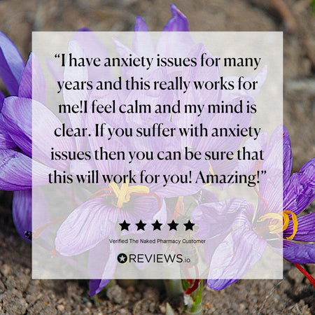 A square review card with a semi-transparent white background and black text, overlaid on a background photo of purple flowers in soil. The text reads a customer testimonial about anxiety relief, with five stars and the name REVIEWS.