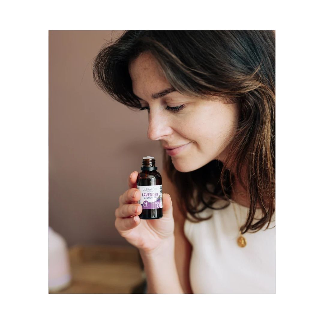 Image of a woman holding the Ultrapure Lavender Essential Oil 10ml container up to her nose