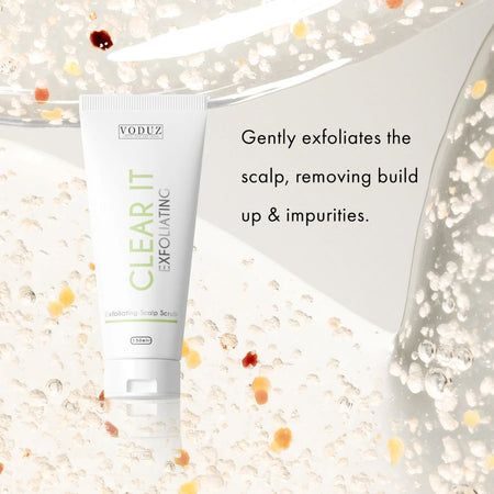 VODUZ Clear It Exfoliating Scalp Scrub in a white squeeze tube, displayed on a clean white background with decorative clear gel droplets and black descriptive text.