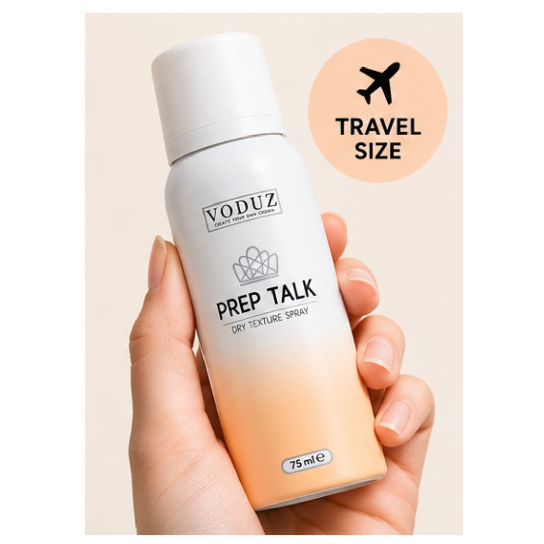 A hand holding a VODUZ Prep Talk dry texture spray aerosol can, which features a white-to-cream gradient design. A peach-colored circular badge in the upper right corner displays the text 'TRAVEL SIZE' with an airplane icon.