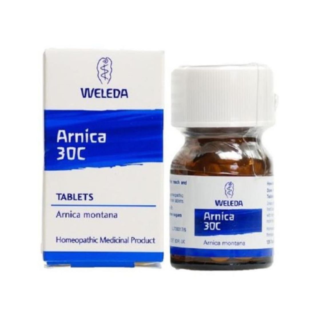 Weleda Arnica 30C homeopathic medicine shown with its white and blue cardboard box next to an amber glass bottle with a white cap.