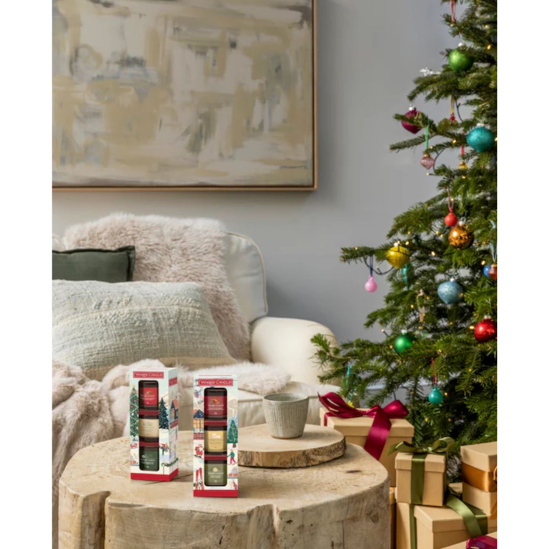 Yankee Candle Mini Votive Set - two sets on a wooden log table with christmas tree in the background