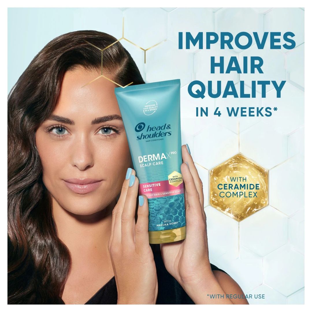 A woman holds a tube of Head & Shoulders Derma-Pro Sensitive Care shampoo against a light blue background with promotional text and a gold hexagon badge.