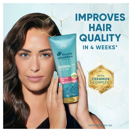 A woman holds a tube of Head & Shoulders Derma-Pro Sensitive Care shampoo against a light blue background with promotional text and a gold hexagon badge.