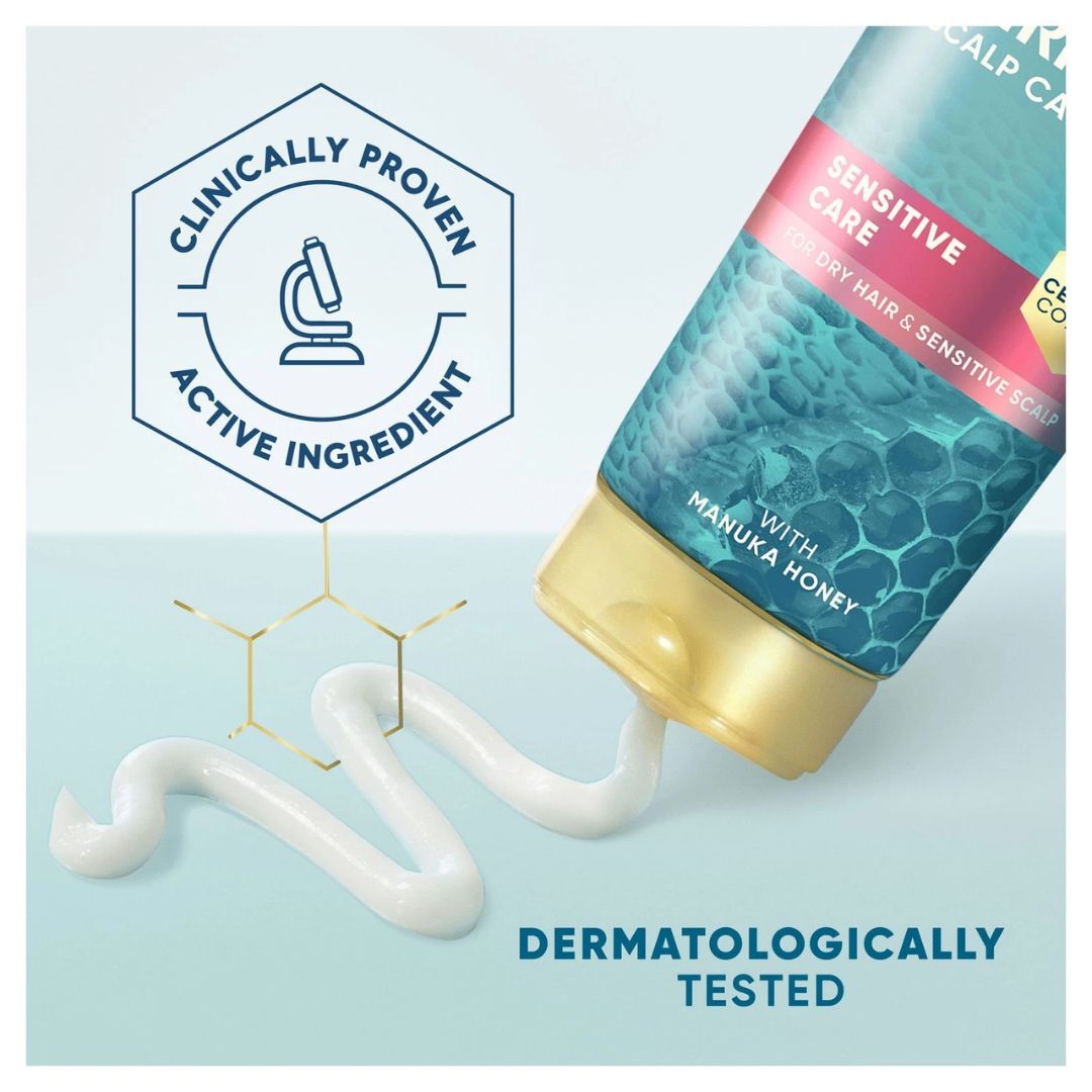 A tube of sensitive scalp hair care cream with a gold cap and white cream squeezed out, shown on a light blue background with a 'Clinically Proven Active Ingredient' badge and 'Dermatologically Tested' text.