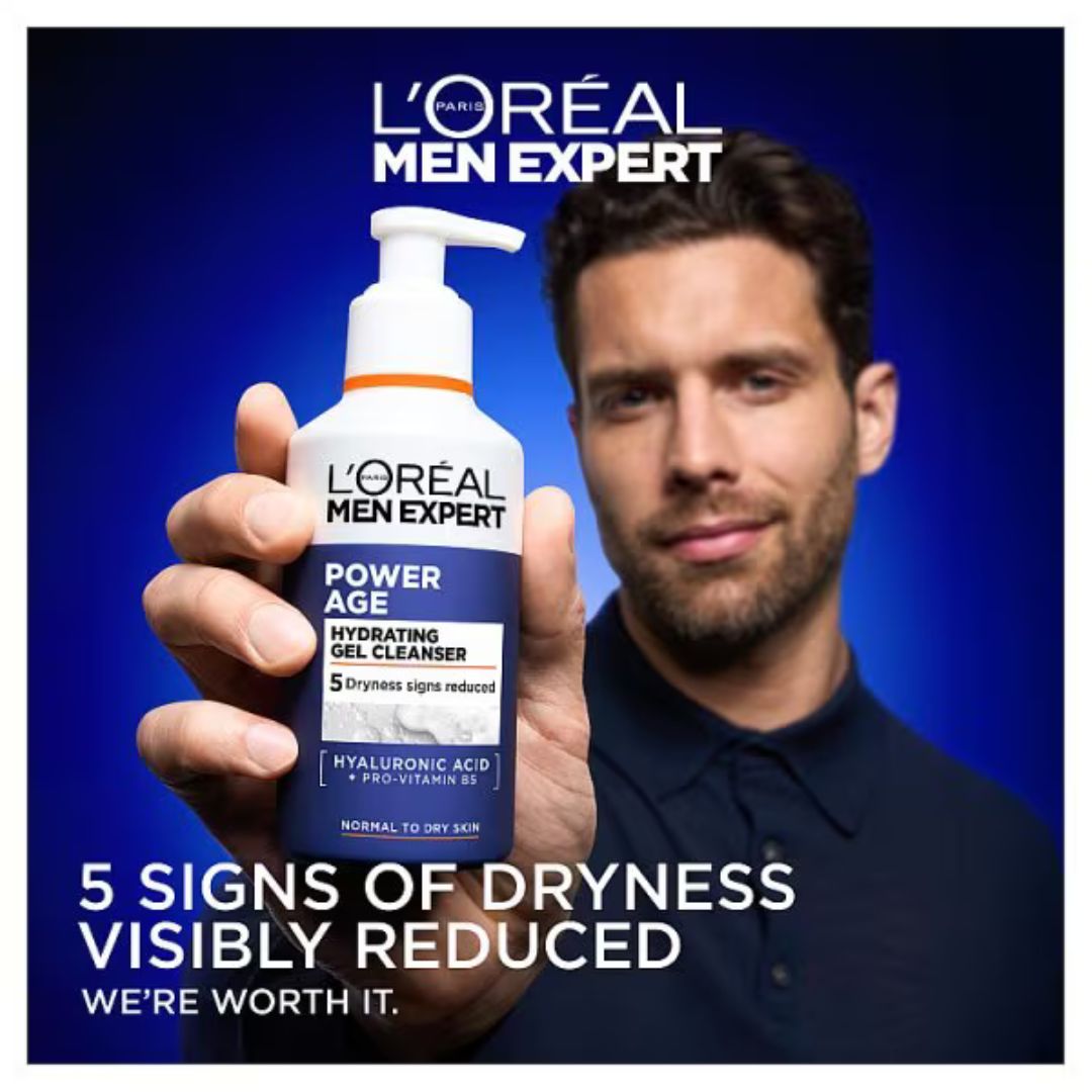 L'Oréal Men Expert Power Age Hydrating Gel Cleanser bottle held up by a man in a dark navy shirt against a blue gradient background, with promotional text overlays.
