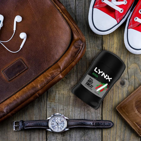 Lynx anti-sweat device on a wooden surface with a watch, earphones, and red sneakers.Lynx Africa Anti-Perspirant Deodorant Stick 50ml
