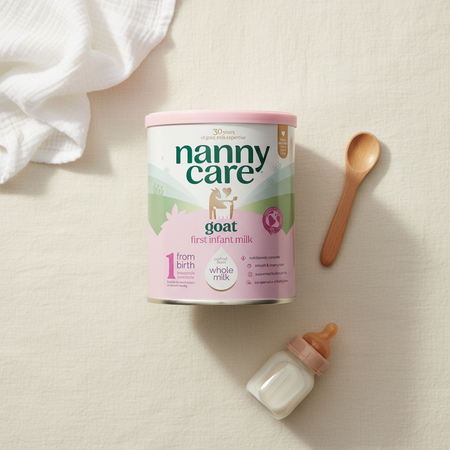 Nannycare goat milkwith spoon and bottle on cream background