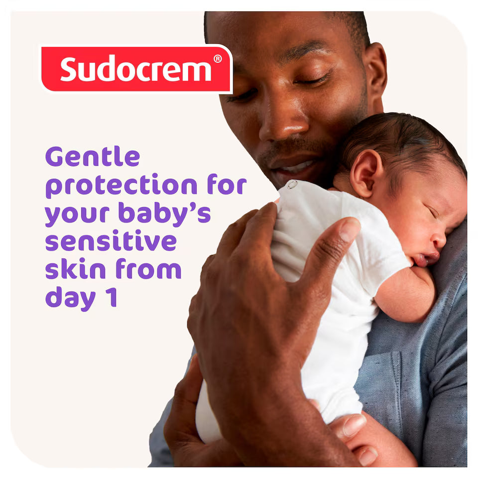 Man holding a baby with Sudocrem branding and text about gentle protection for sensitive skin.