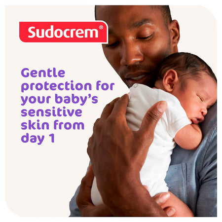Man holding a baby with Sudocrem branding and text about gentle protection for sensitive skin.