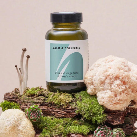 Supplement bottle labeled 'Calm & Collected' on a natural background with plants and stones.